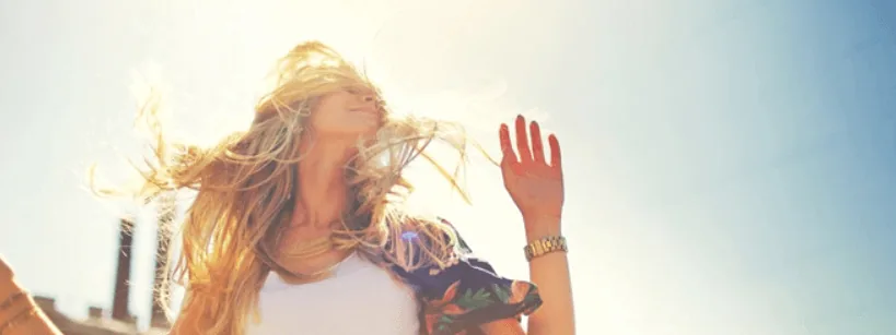 Woman with healthy, flowing hair in bright sunlight